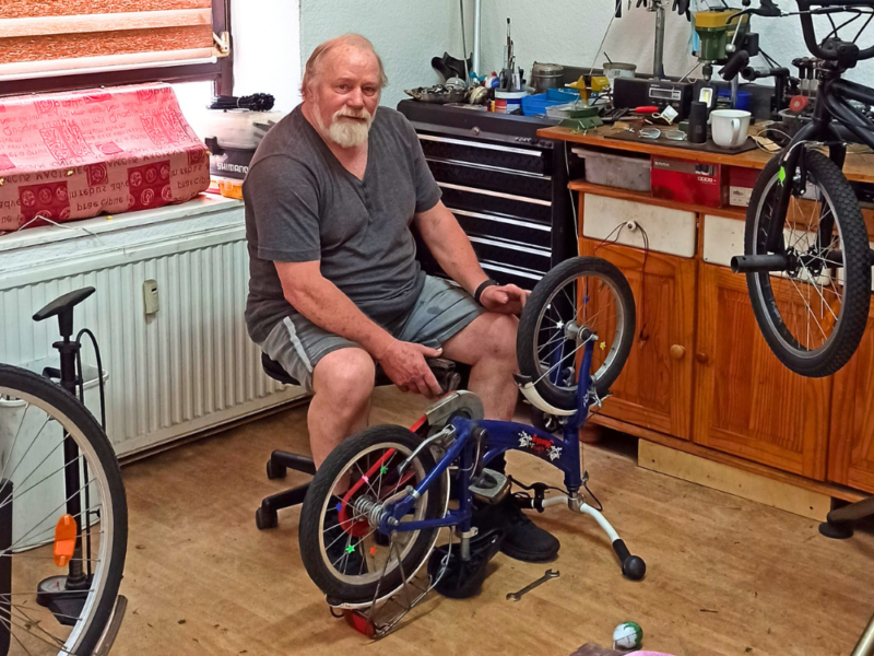 Fahrrad-Selbsthilfewerkstatt Rostlaube mit Betreiber Heinz Tebelmann bei der Reparatur eines Kinderfahrrads