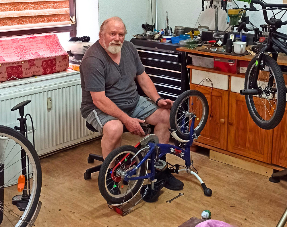 Fahrrad-Selbsthilfewerkstatt Rostlaube mit Betreiber Heinz Tebelmann bei der Reparatur eines Kinderfahrrads
