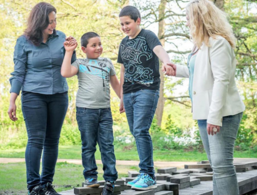 Familie im Stadtteil: Zwei Frauen führen zwei Kinder über eine Erhöhung