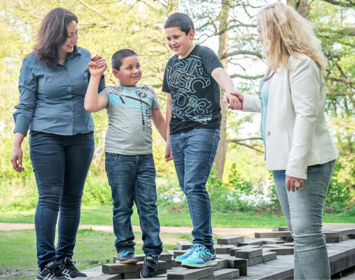 Familie im Stadtteil: Zwei Frauen führen zwei Kinder über eine Erhöhung